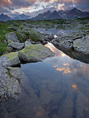 Clouds at dusk mirroring in an alpine lake