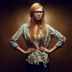 Portrait of a young beautiful red-haired wearing trendy glasses