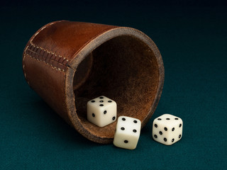 Three playing bones and leather cup