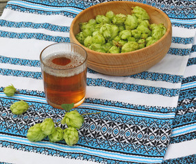 A glass with a drink of hops  and  branch of hops