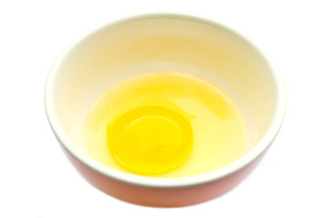 Raw egg in a cup on a white background