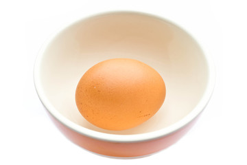 Raw egg in a cup on a white background