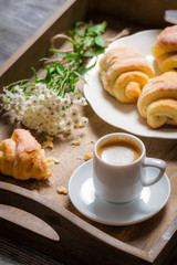 Flowers, croissant and coffee for breakfast