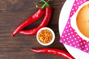chicken soup with chili peppers on wood table