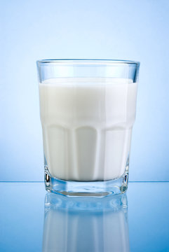 Glass of fresh milk isolated on blue background
