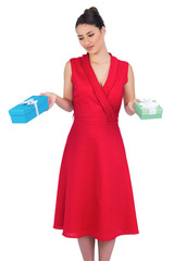 Content glamorous model in red dress offering presents