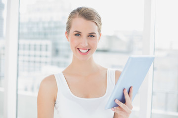 Cheerful sporty woman using tablet pc