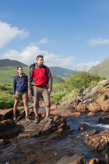 Couple crossing a stream together