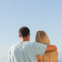 Rear view of cute couple admiring blue sky