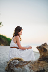 a nice girl sits on the sea shore