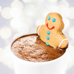Gingerbread cookie man take a bath in cup of Hot Chocolate, over