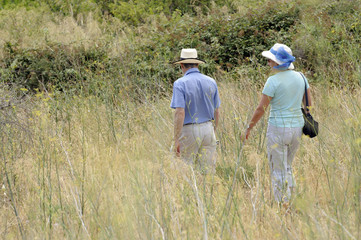 Couple walking in long grass french countryside