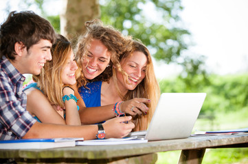 Group of young student using laptop outdoor,Italy