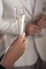 Hand holding glass of champagne in party