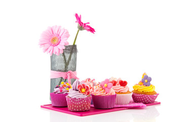 Colorful cupcakes on tray with flowers