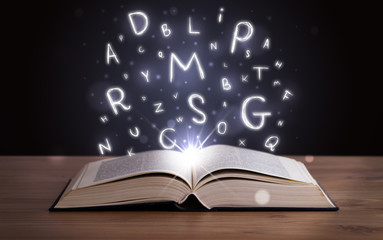 Open book with glowing letters flying out