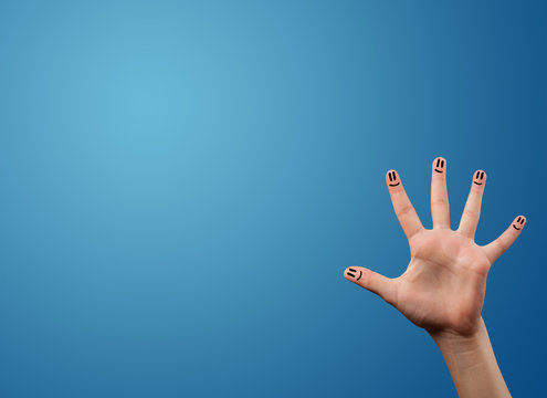 Happy smiley face fingers looking at empty blue background copy