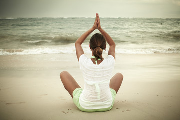 Fototapeta na wymiar Kobieta robi joga na plaży miasta Punta Cana.