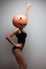Dancing pretty woman with pumpkin on head