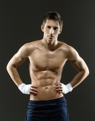 Fototapeta na wymiar Half-length portrait of half-naked boxer with hands on hips