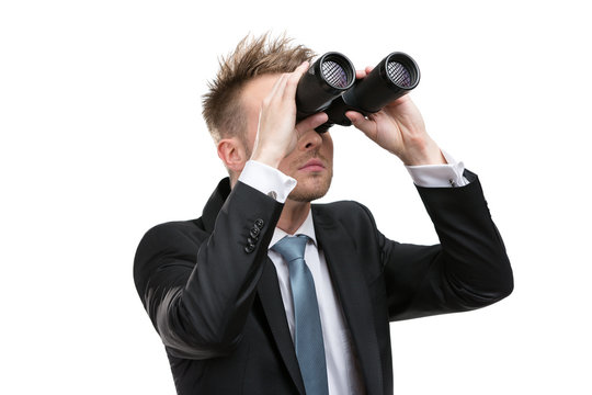 Business man wearing suit with blue tie hands binoculars