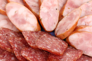 Tasty sliced sausage on plate close-up