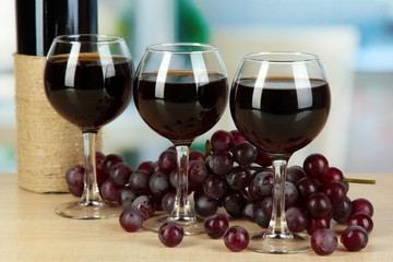 Red wine in glass on room background