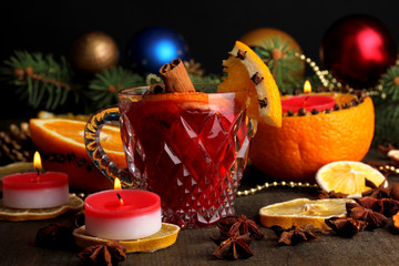 Fragrant mulled wine in glass with spices and oranges around