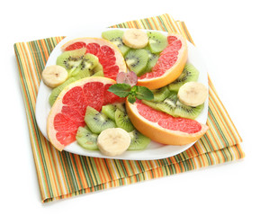 Assortment of sliced fruits on plate, isolated on white