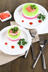 Colored rice on plates on napkins on wooden table