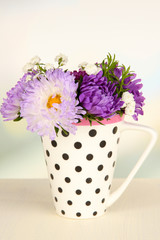 Beautiful bouquet of bright flowers in color mug,