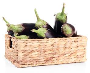 Fresh eggplants in wicker basket isolated on white