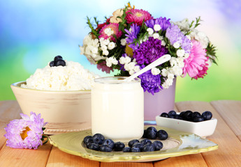 Fresh dairy products with blueberry on wooden table close-up