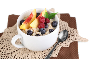 Oatmeal in cup with berries on napkins isolated on white