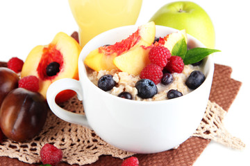 Oatmeal in cup with berries on napkins isolated on white