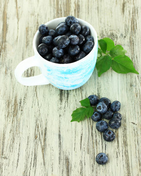Blueberries in cup on wooden table