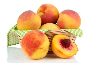 Ripe sweet peaches in wicker basket, isolated on white