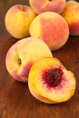 Fototapeta na wymiar Ripe sweet peaches, on wooden background