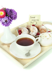 Cup of tea with cakes on wooden tray isolated on white