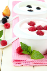 Delicious yogurt with fruit and berries on table close-up