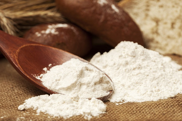 flour on a wooden spoon and bread