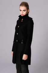 portrait of a beautiful young woman in black coat posing