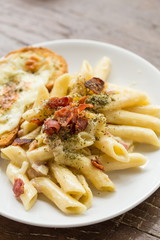 Penne Pasta with Ham and Cheese on wooden table