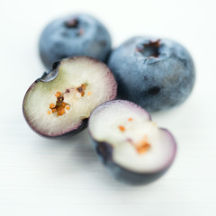 Whole and halved blueberries, macro shot, white background