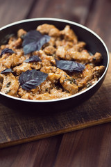 Roasted pork with basil leaves, close-up, vertical shot