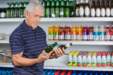 Senior Man Comparing Beer Bottles