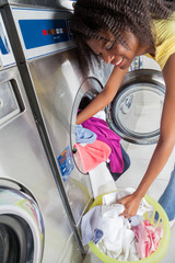 Woman Loading Dirty Clothes In Washing Machine