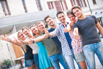 Group of young friends thumbs up