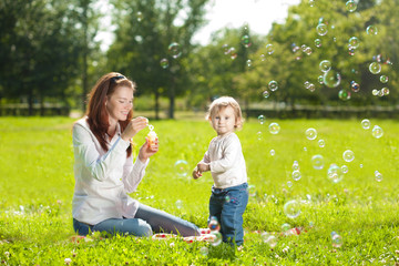 Obraz premium Beauty Mom and baby outdoors. Happy family playing in nature. Mo