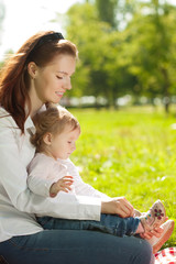 Beauty Mom and baby outdoors. Happy family playing in nature. Mo